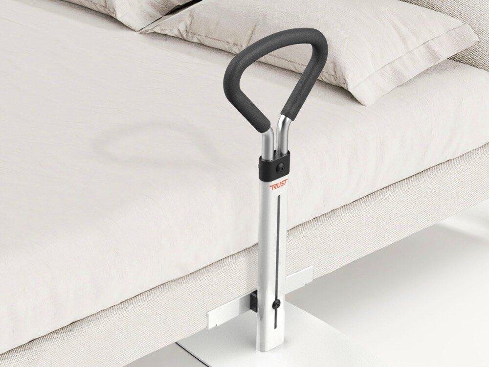 Person reser sig upp vid sängen med hjälp av Let's Get Up uppresningsstöd