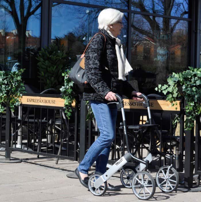 Äldre dam promenerar utomhus med Trust Care Let’s Go Out rollator